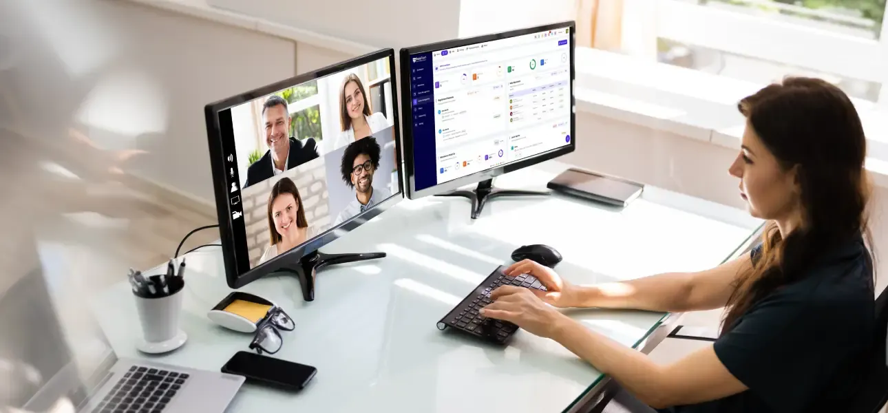 Woman working on a desktop and attending the video team meeting