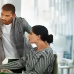 Corporate manager pointing at calendar and workforce management and timesheet software open on screen